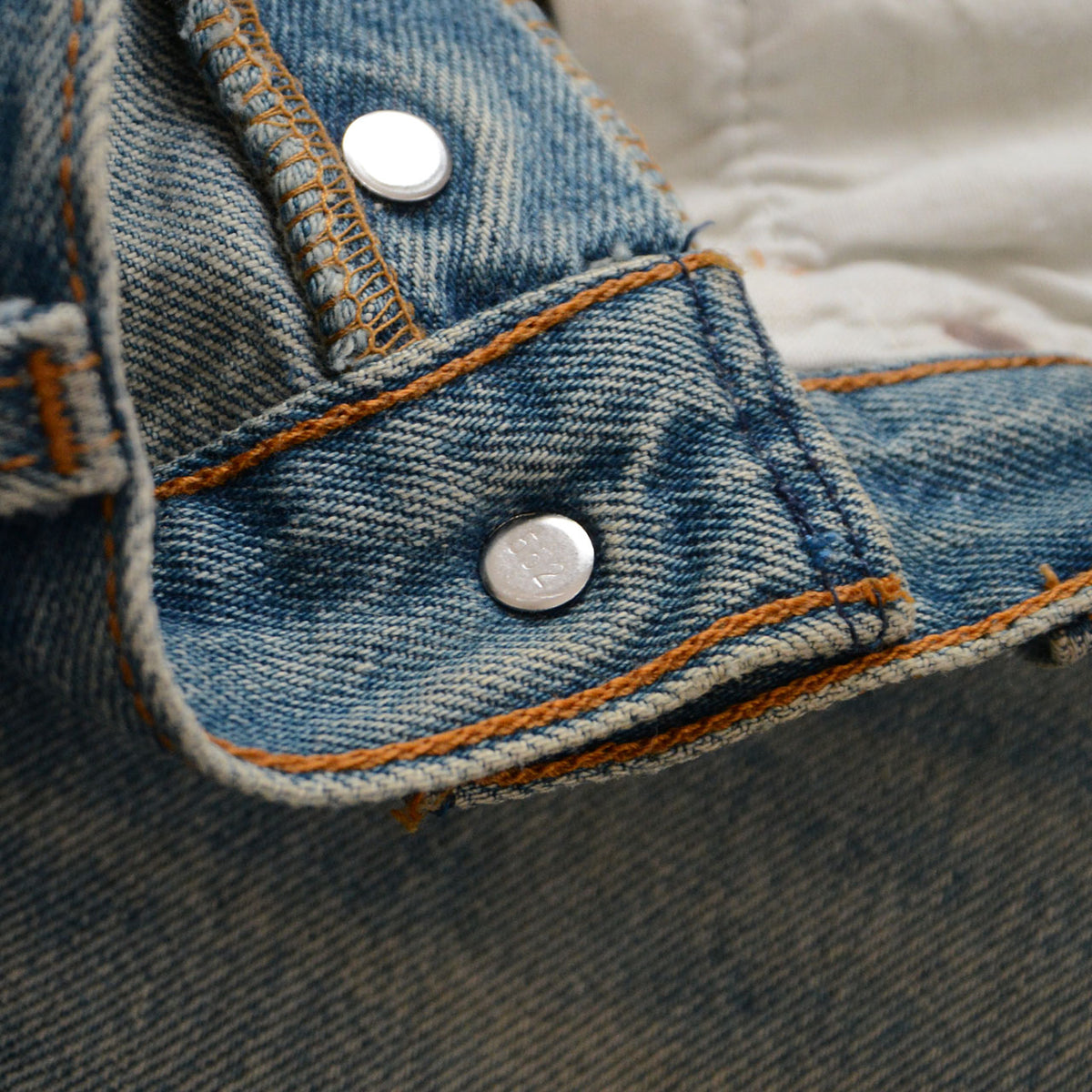 Levi’s 501 top button back stamped 552 with orange stitching on blue denim