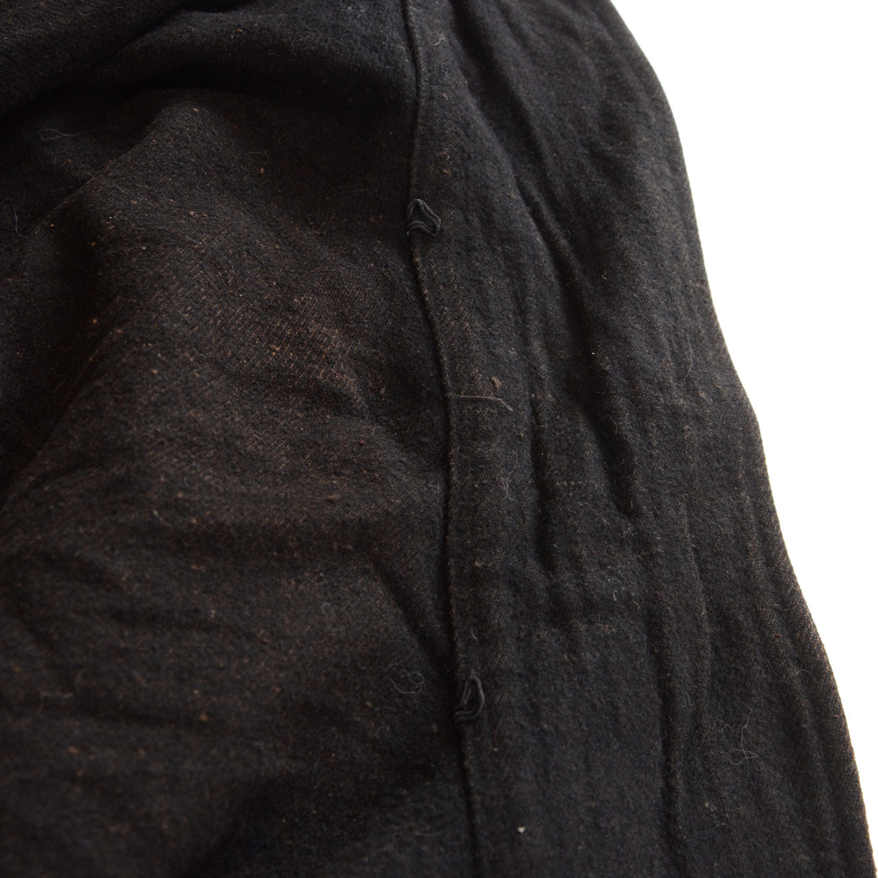 Black wool surface of a prewar Japanese mantle with age-related marks