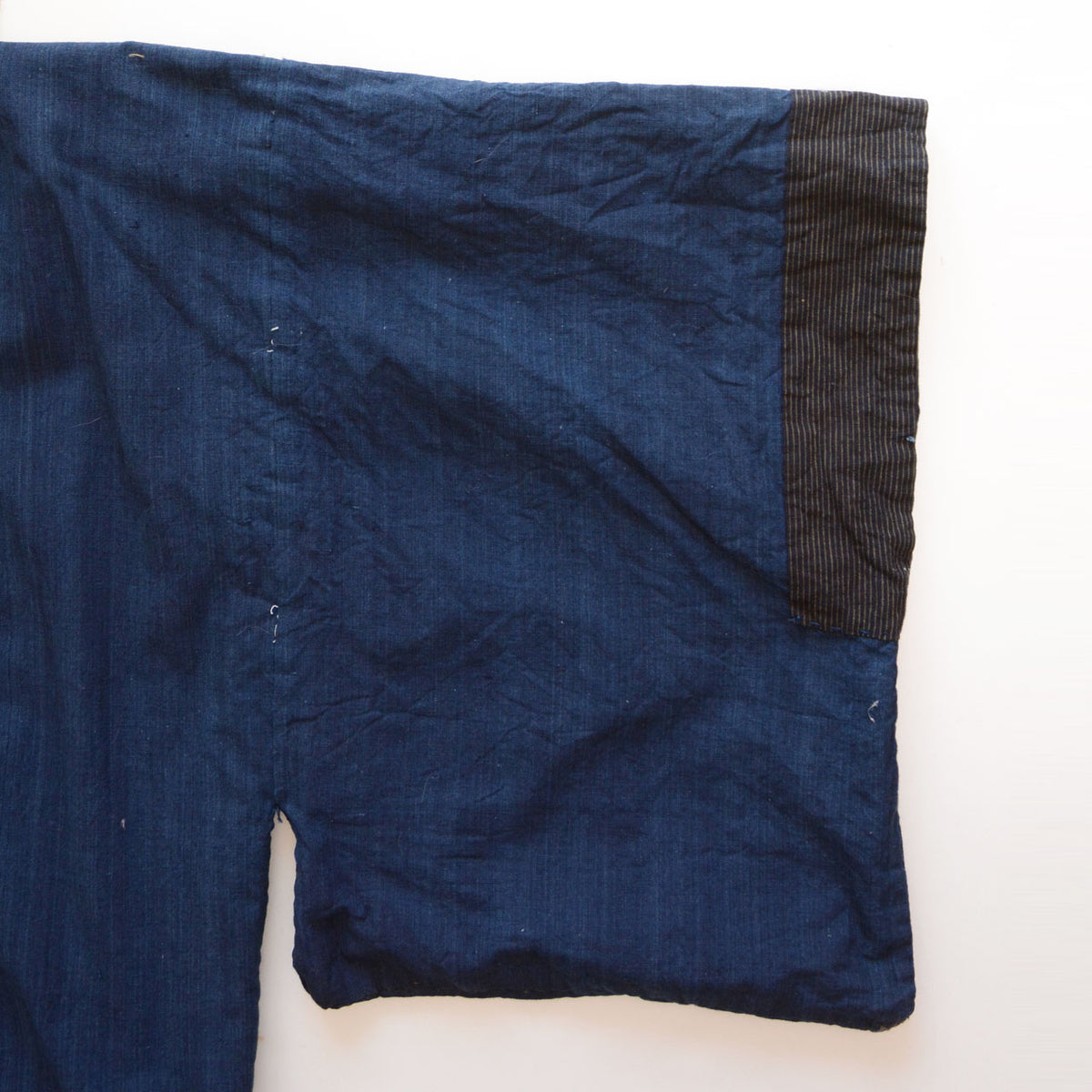 Solid indigo cotton lining and striped sleeve cuff of a men's kimono