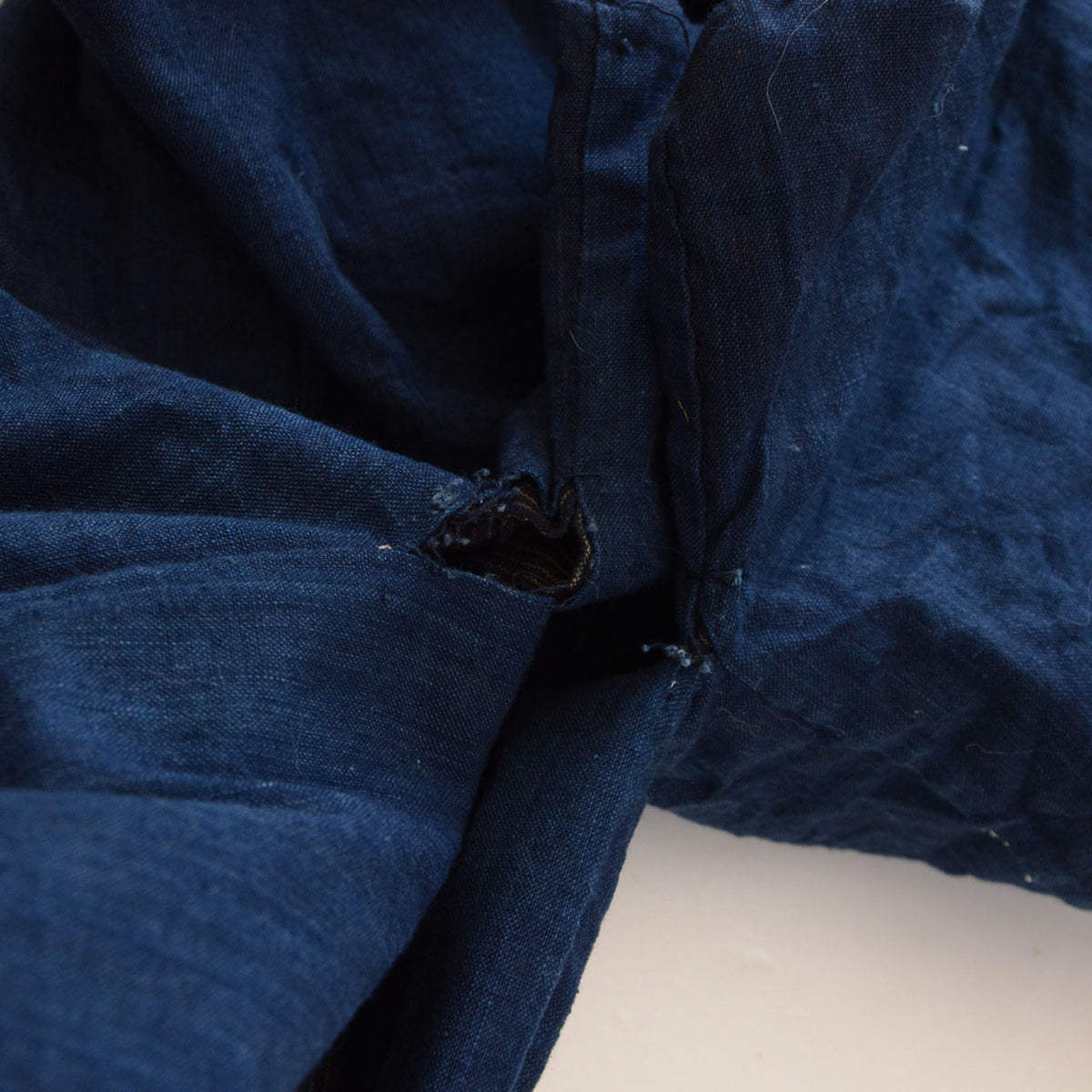 Loose underarm stitching and open seam of a vintage indigo cotton kimono