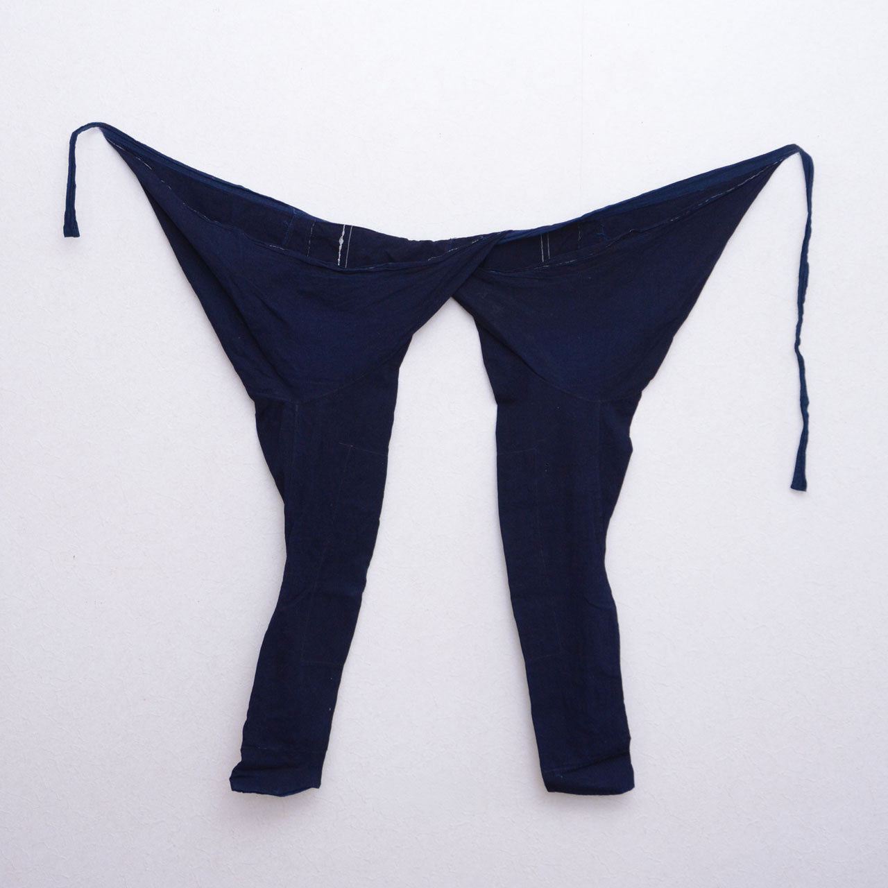 Indigo cotton momohiki displayed on a wall, showing the full silhouette