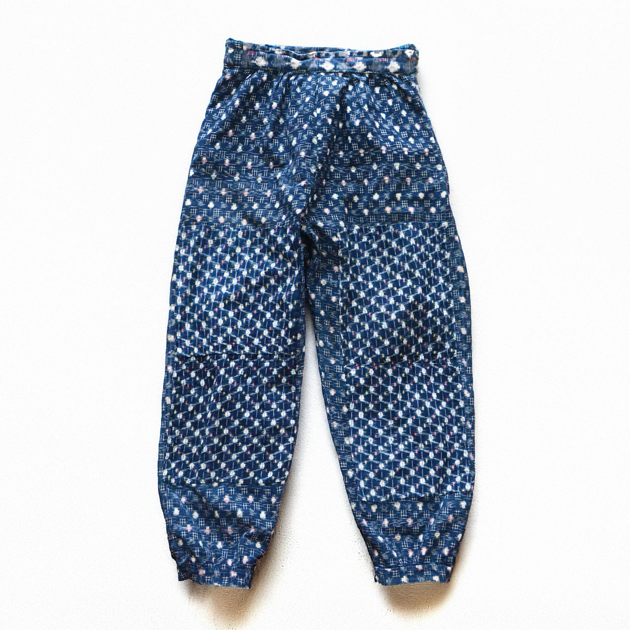 Indigo kasuri cotton mompe pants, front, crazy patchwork of multiple kasuri fabrics, white and multicolor ikat motifs on deep navy ground, mid-Showa vintage Japan