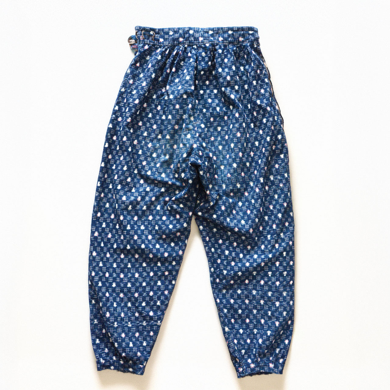 Indigo kasuri cotton mompe pants, back, crazy patchwork of multiple kasuri fabrics, white and multicolor ikat motifs on deep navy ground, mid-Showa vintage Japan