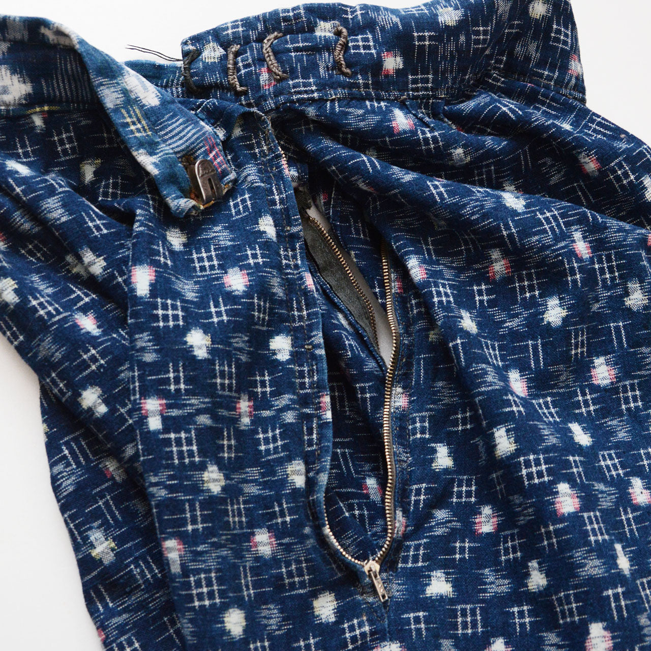 Side zipper opening on indigo kasuri mompe, patchwork kasuri cotton with varied ikat patterns, mid-Showa vintage Japan