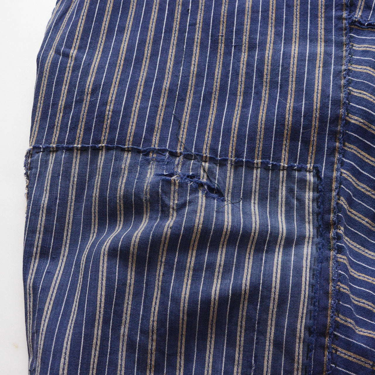 Damage detail on stripe cotton monpe pants, worn hole and frayed blue stripe cotton, boro condition, Tohoku Japan vintage