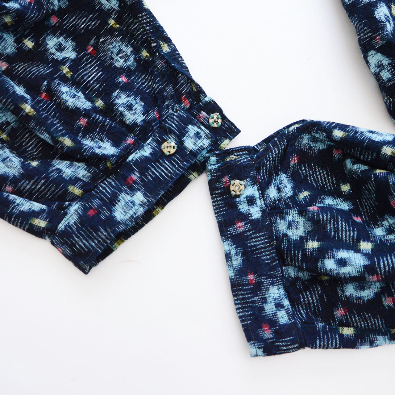 indigo kasuri cotton monpe — ankle cuff detail with vintage fabric-covered buttons, kasuri weave texture