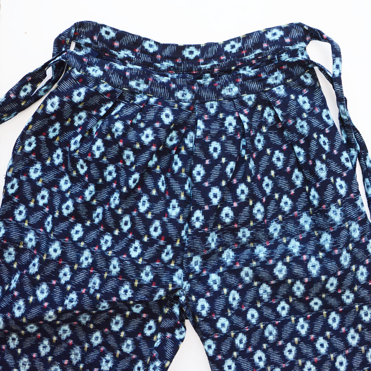 indigo kasuri cotton monpe — waistband and tie cord detail, kasuri ikat pattern on navy cotton, gathered waist