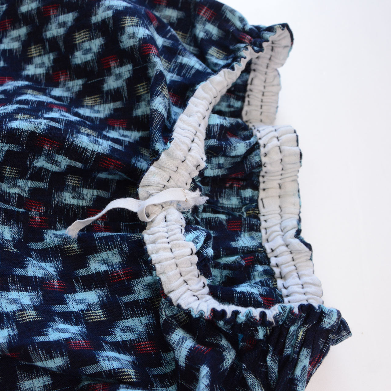 Elastic waist detail of indigo kasuri cotton monpe pants, gathered waistband, navy ikat pattern, Mid-Showa era Japan vintage