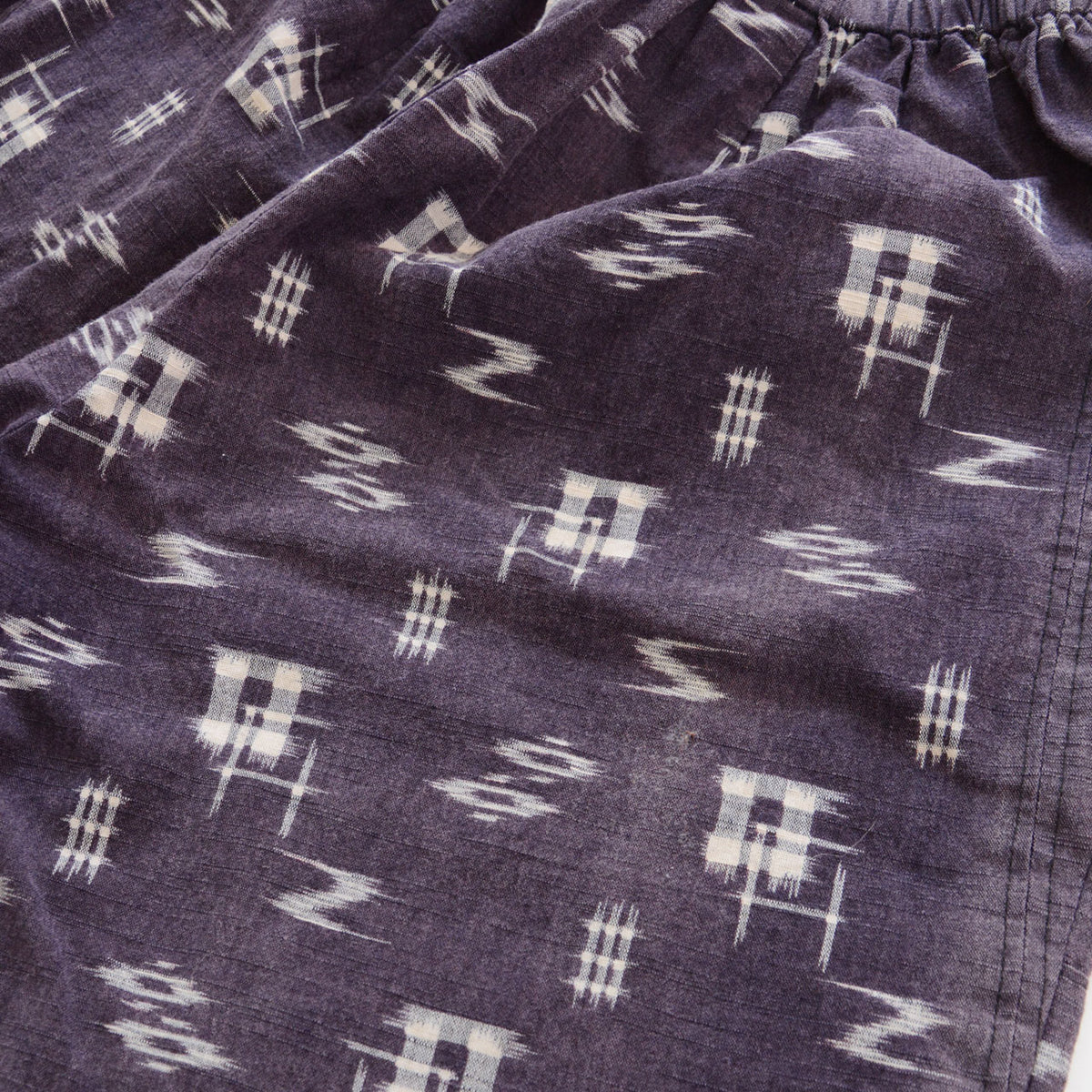 White geometric kasuri motifs and woven cotton texture of Showa-era Japanese vintage monpe pants