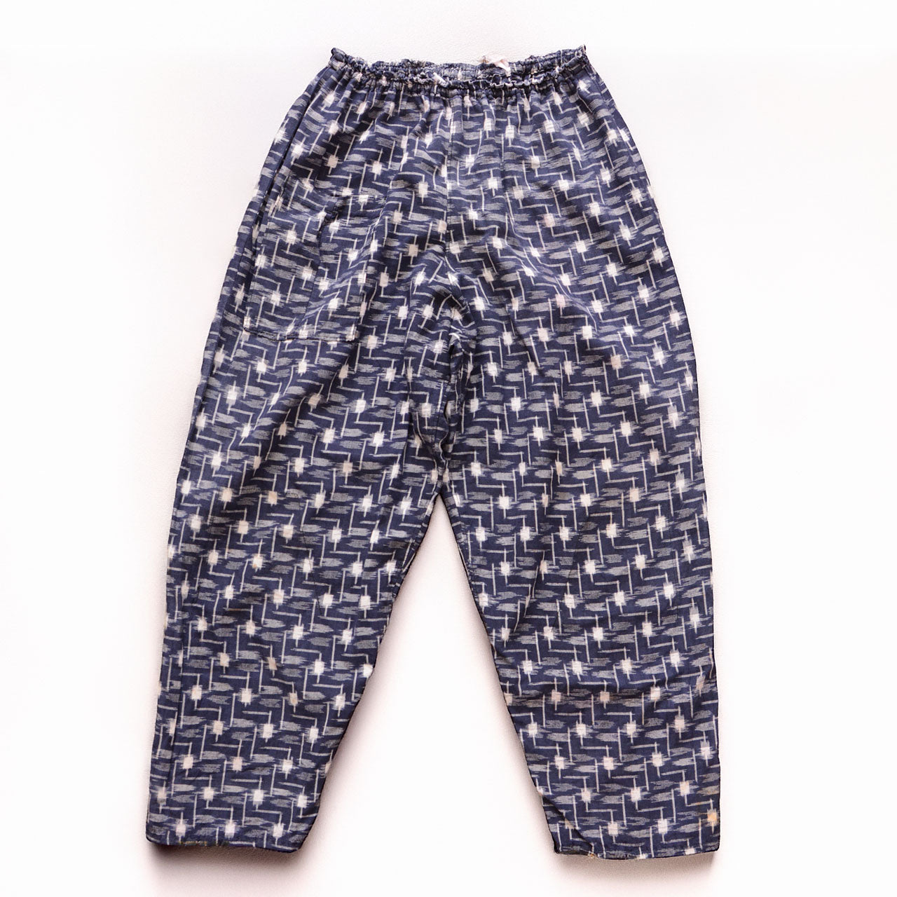 Vintage kasuri monpe pants, front view, navy cotton with white geometric ikat pattern, elastic waist, wide-leg silhouette, mid-Showa era Japan