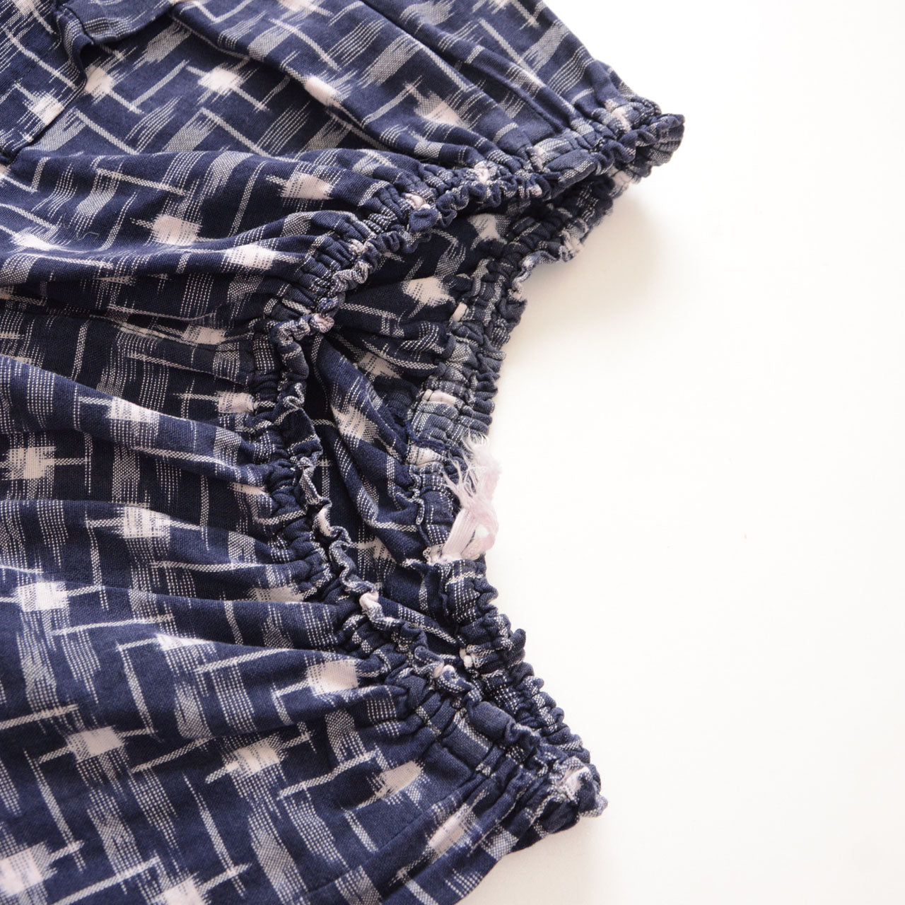 Elastic waistband of vintage kasuri monpe pants, navy cotton ikat weave, gathered ruching detail