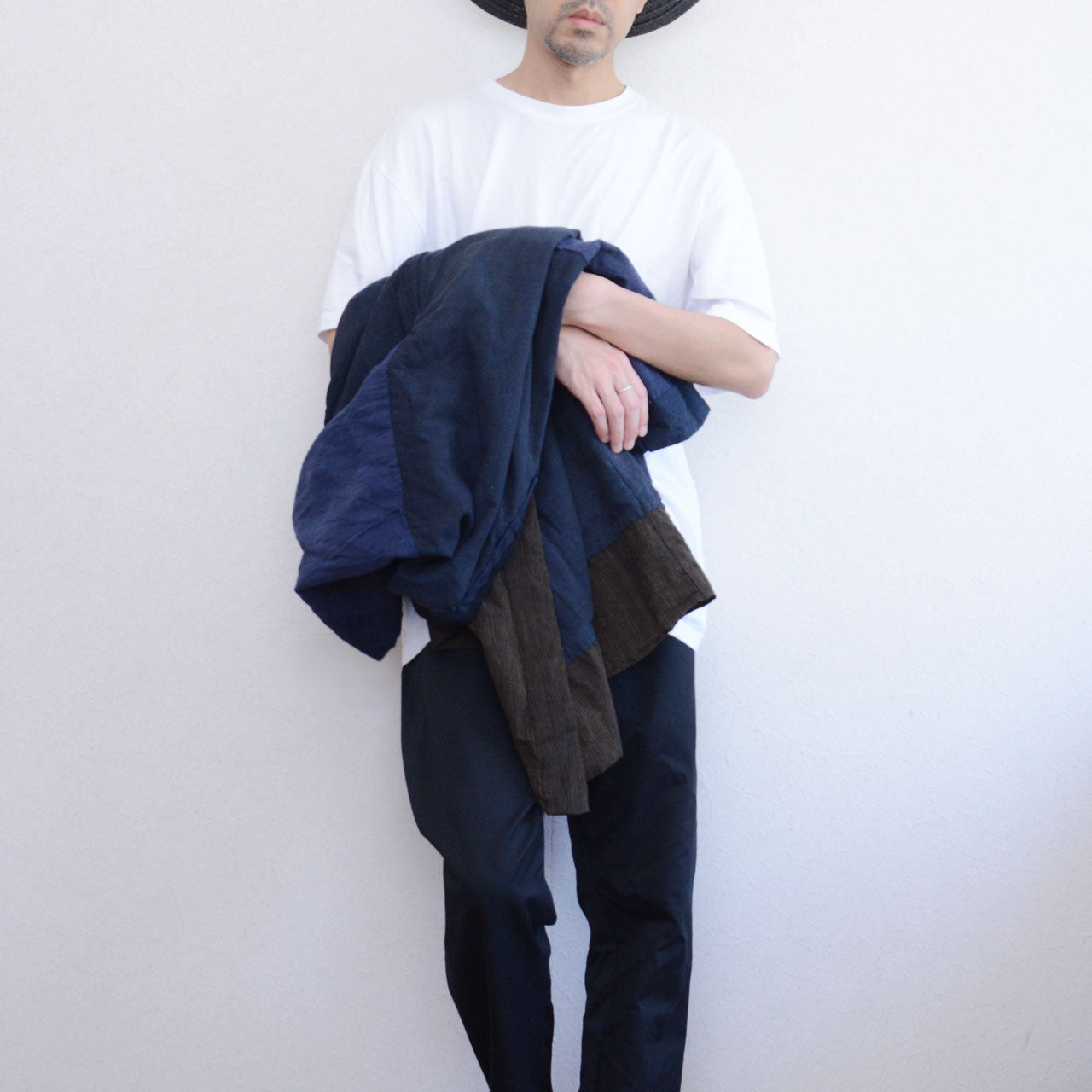 Boro noragi jacket, indigo-dyed cotton outer with striped crazy pattern lining, carried over arm, Japan vintage styling, pre-WWII Tohoku