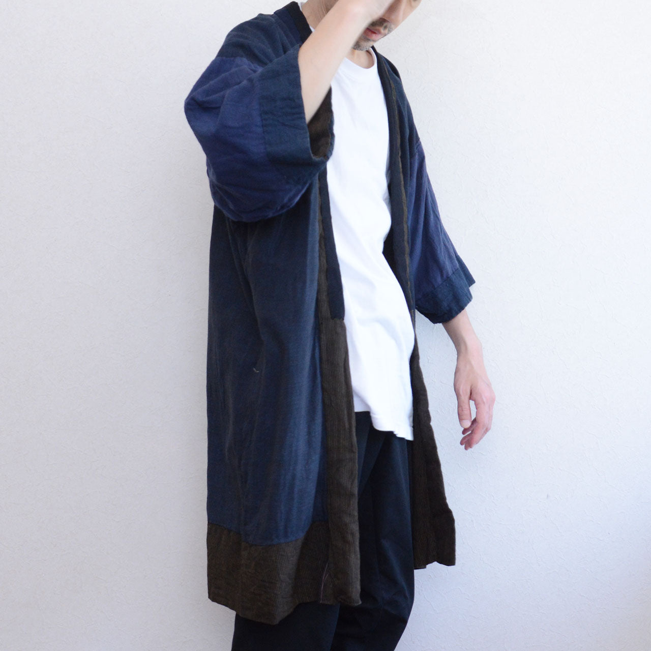 Boro noragi jacket, indigo-dyed cotton outer with striped crazy pattern lining, open front side view, worn over white tee and dark trousers, Japan vintage styling, pre-WWII Tohoku
