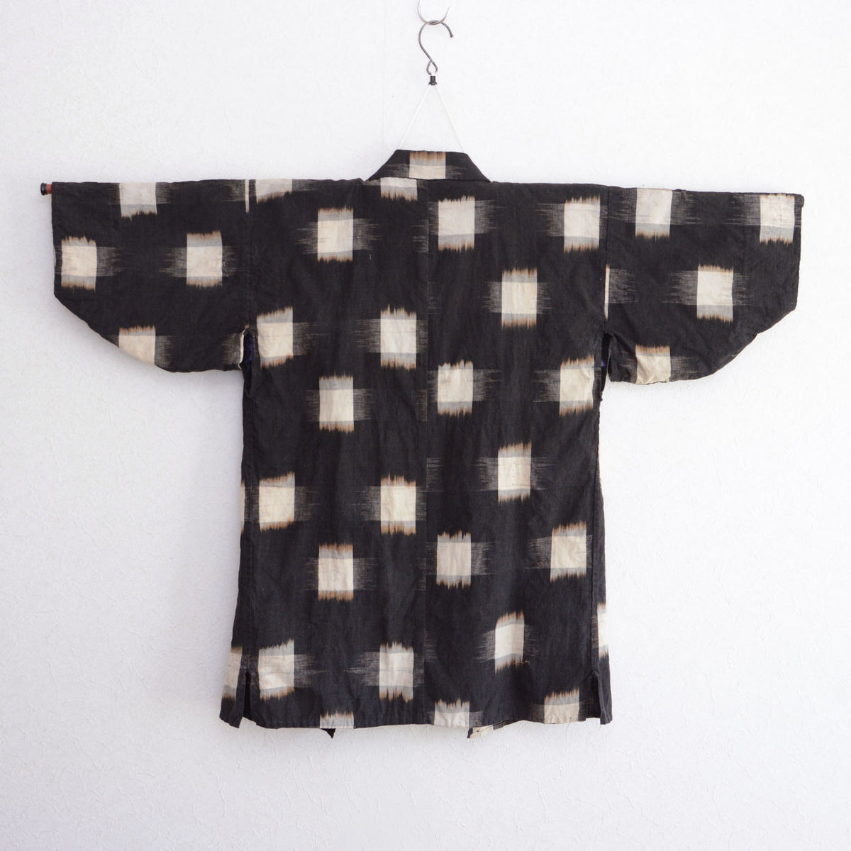 Large ecru kasuri motifs and central seam on a dark Japanese vintage cotton noragi.