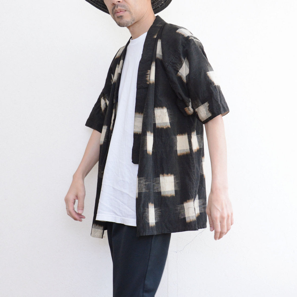 Dark kasuri cotton noragi with ecru motifs, white T-shirt and dark trousers.