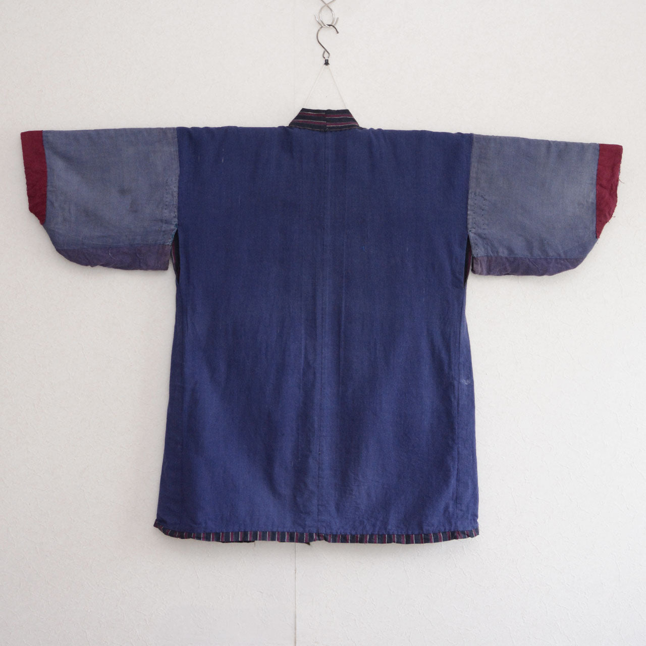 Reverse side of a vintage Japanese noragi showing blue, grey-blue, red, and striped fabric sections