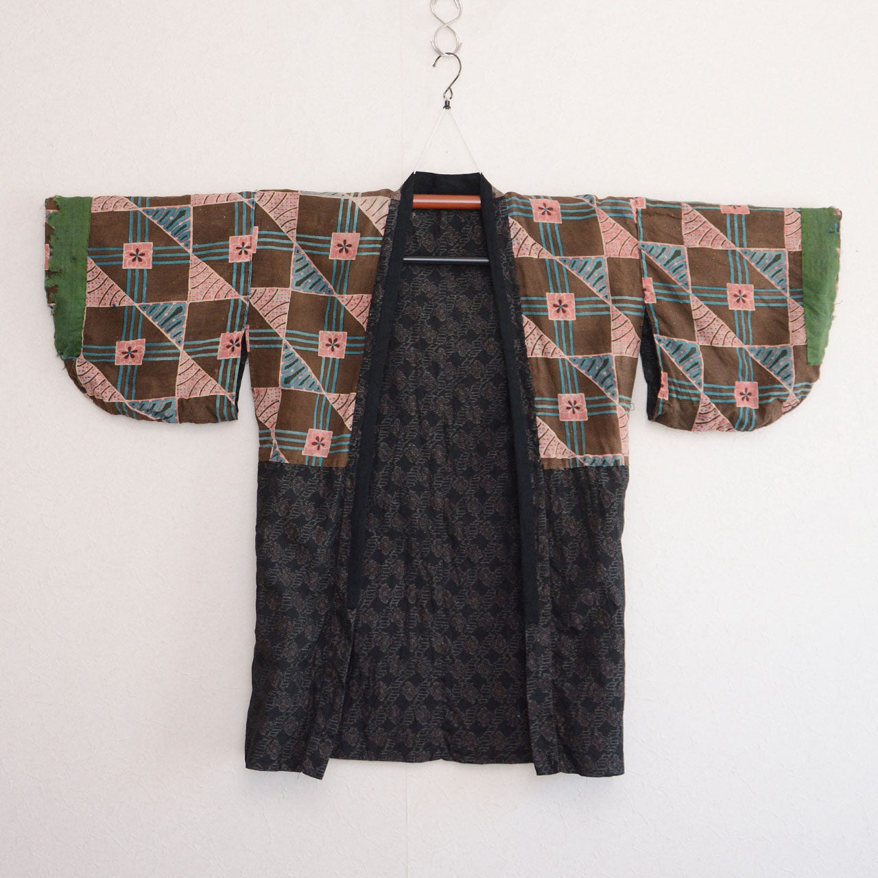 Vintage Japanese noragi jacket, reverse side, floral cotton lining, front view, displayed on kimono hanger, Showa era