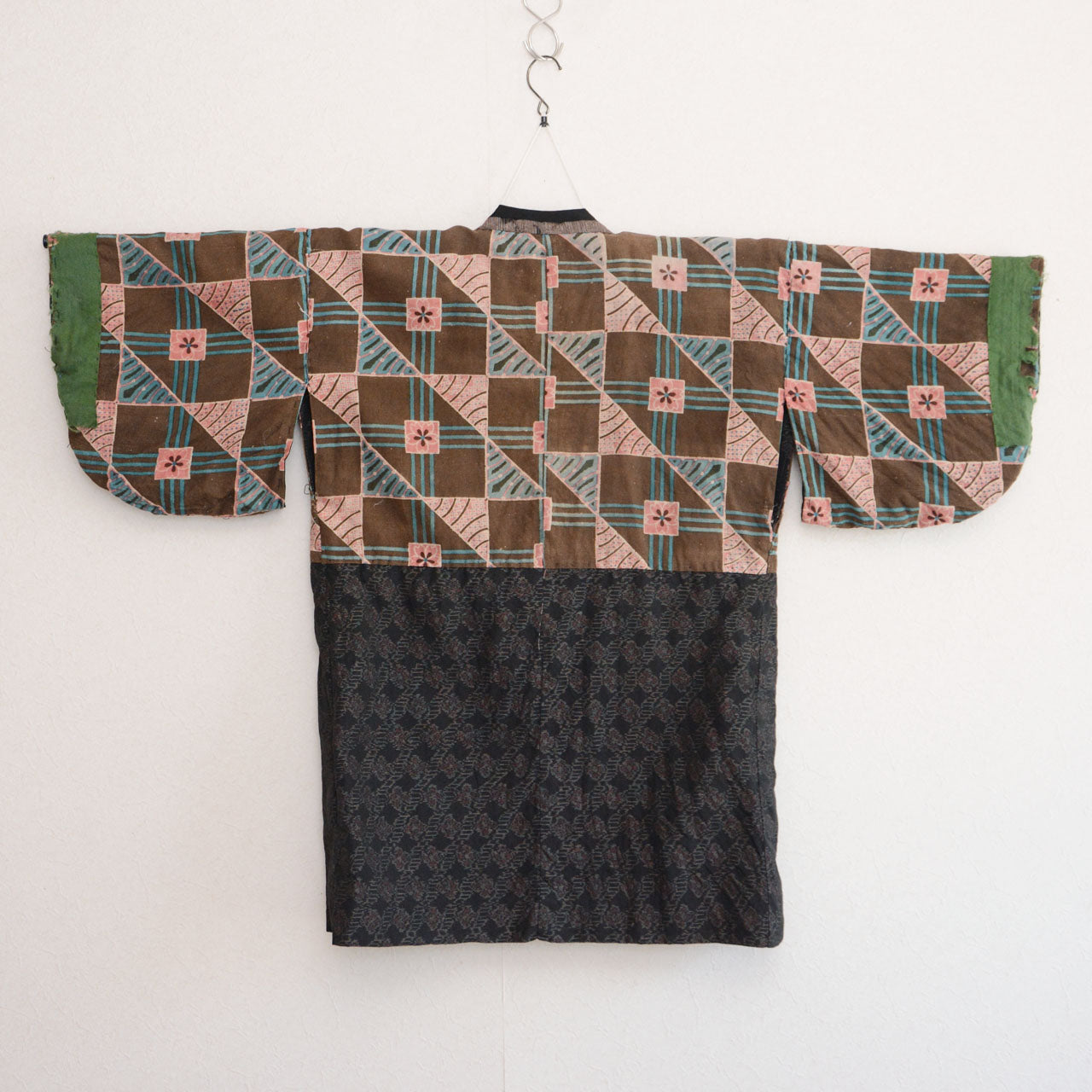 Vintage Japanese noragi jacket, reverse side, floral cotton lining, back view, displayed on kimono hanger, Showa era
