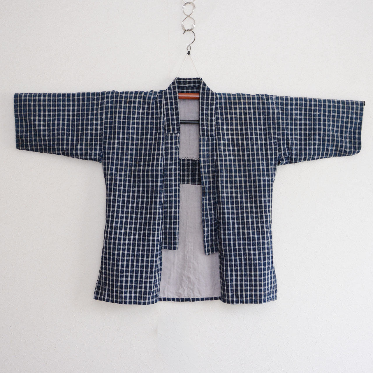 Vintage noragi jacket on hanger, front view — indigo-dyed cotton check, white grid on navy ground, early Showa era Japan vintage