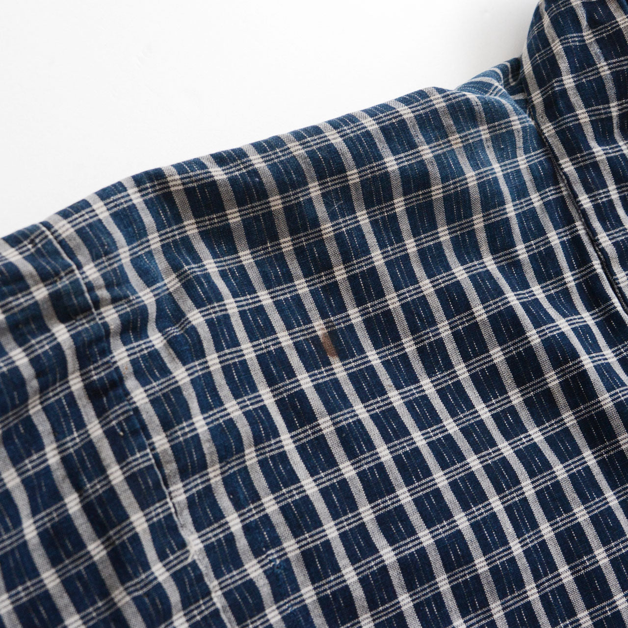 Shoulder detail of a vintage noragi jacket — indigo-dyed cotton check, hand-stitched construction, early Showa era Japan vintage