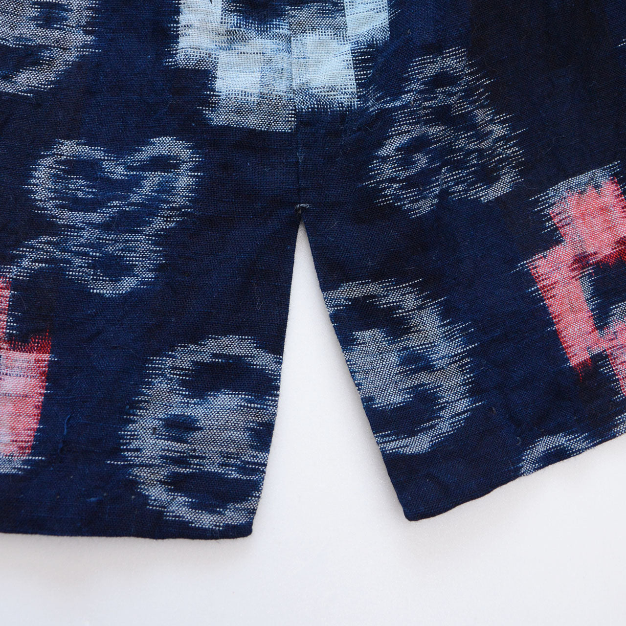 Indigo-dyed cotton noragi jacket, e-gasuri ikat weave, navy ground with multi-motif kasuri pattern in white and red, side slit detail, Japan vintage