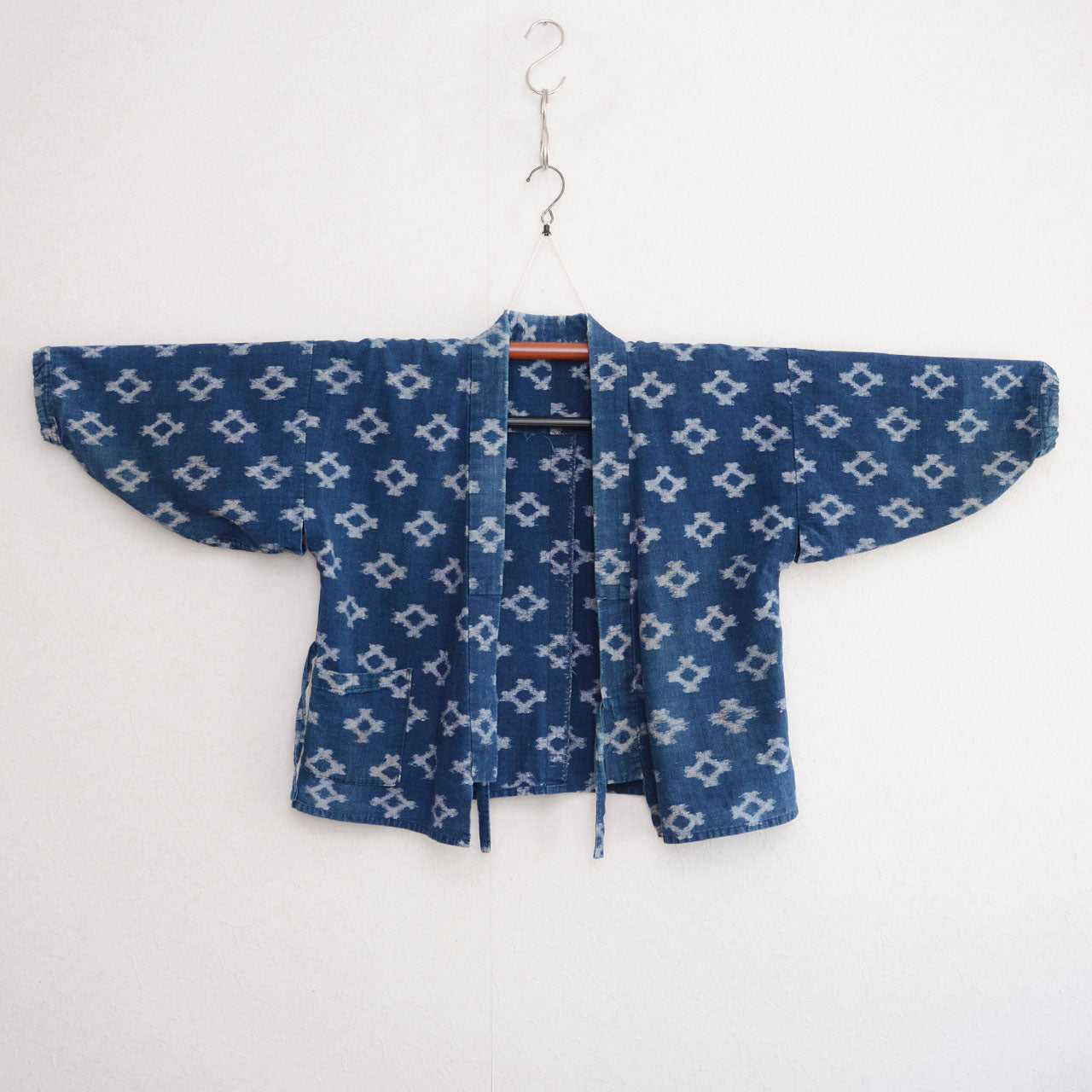 Indigo kasuri noragi jacket on kimono hanger, diamond ikat cotton, Japan vintage workwear, front view