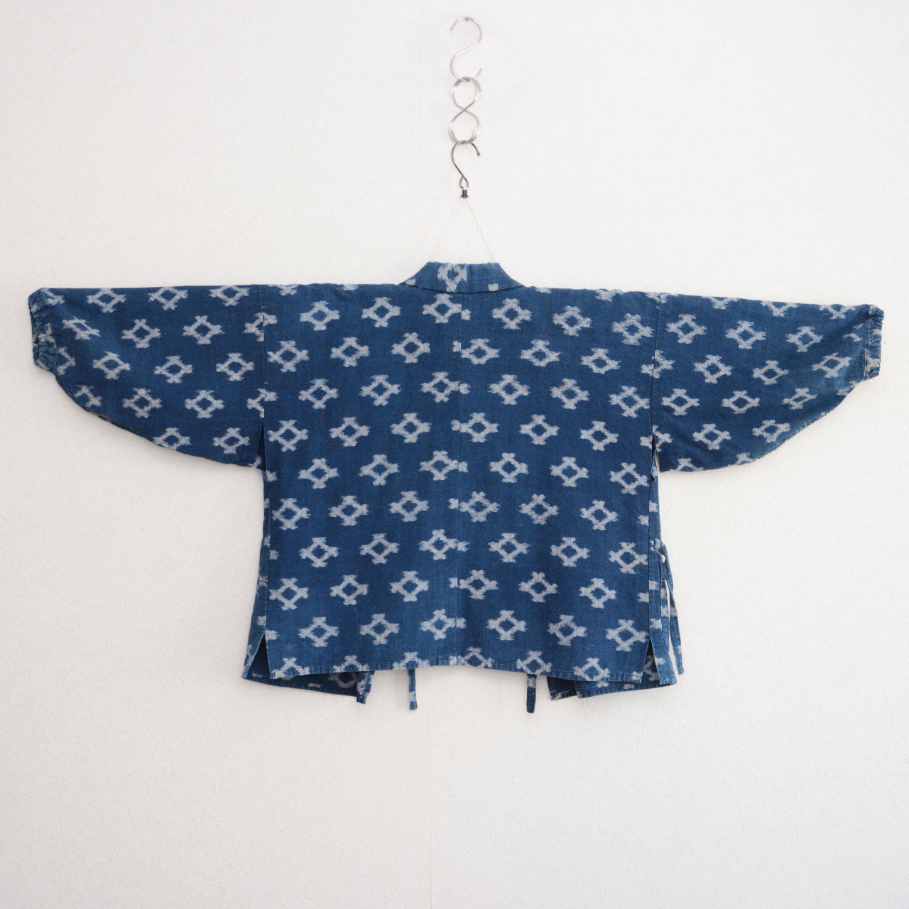 Indigo kasuri noragi jacket on kimono hanger, diamond ikat cotton, Japan vintage workwear, back view