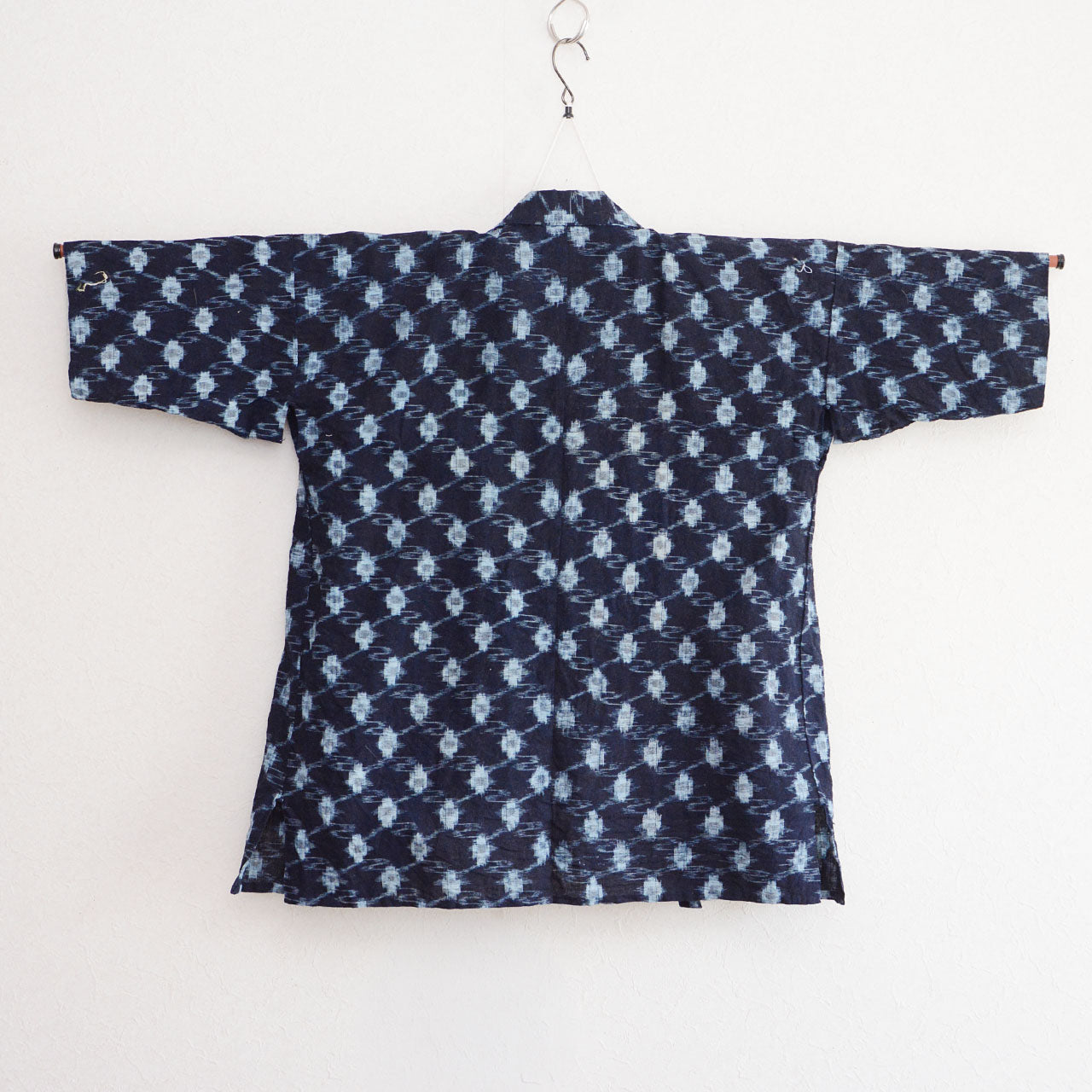 Indigo kasuri cotton noragi jacket, navy, diamond ikat pattern, back view, Showa era Japan vintage, on hanger
