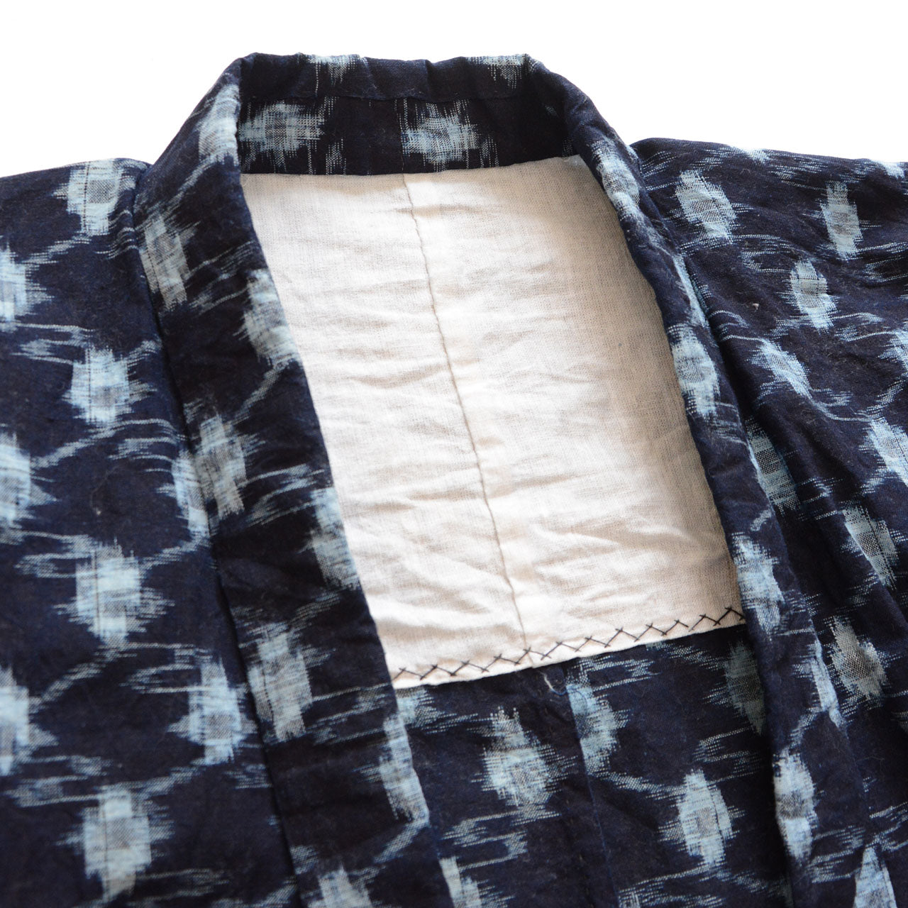 Collar and lining detail, indigo kasuri noragi jacket, natural cotton lining with hand-stitching, navy diamond ikat exterior, Showa era Japan vintage