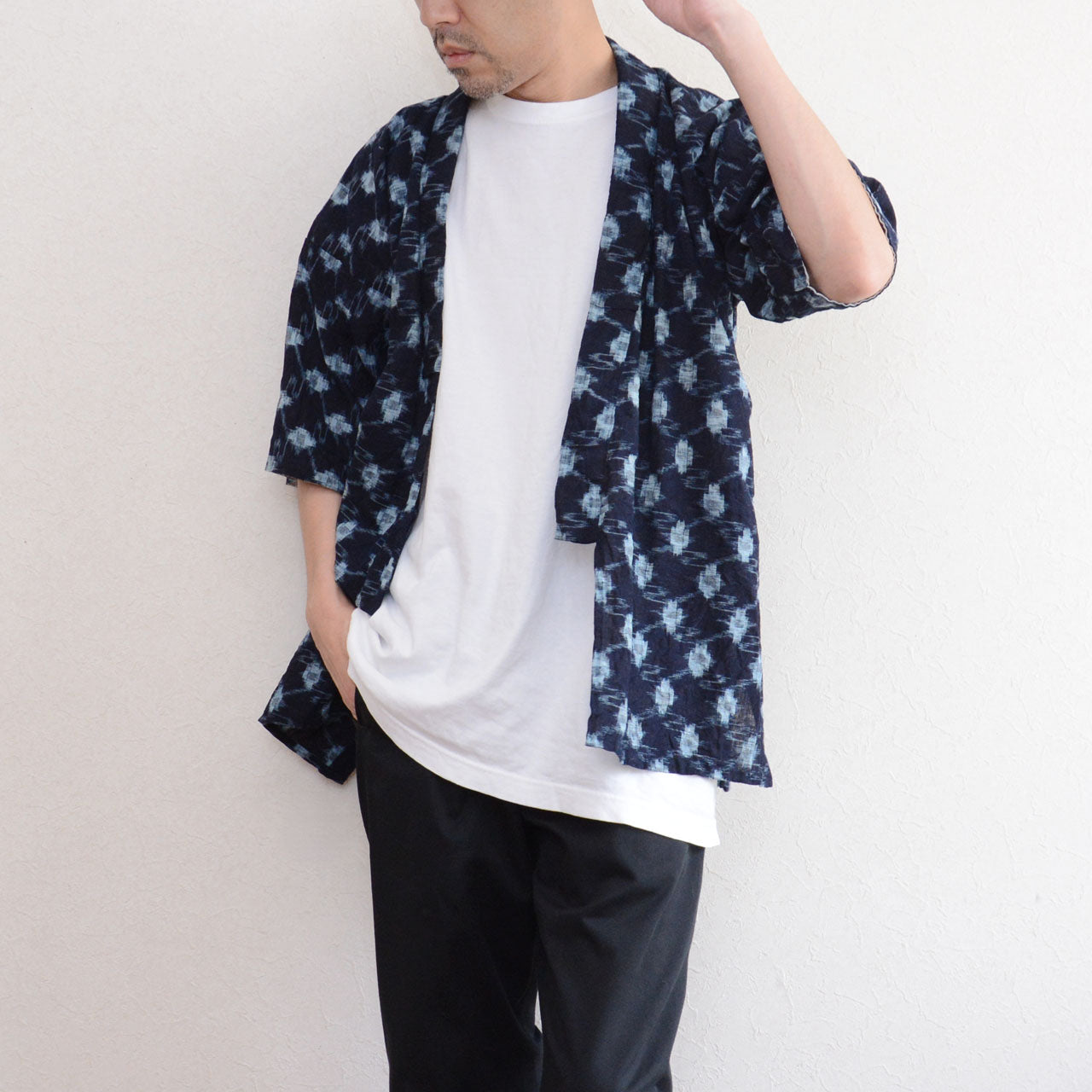 Indigo kasuri noragi jacket worn open over white tee and black trousers, men, straw hat, Showa era Japan vintage