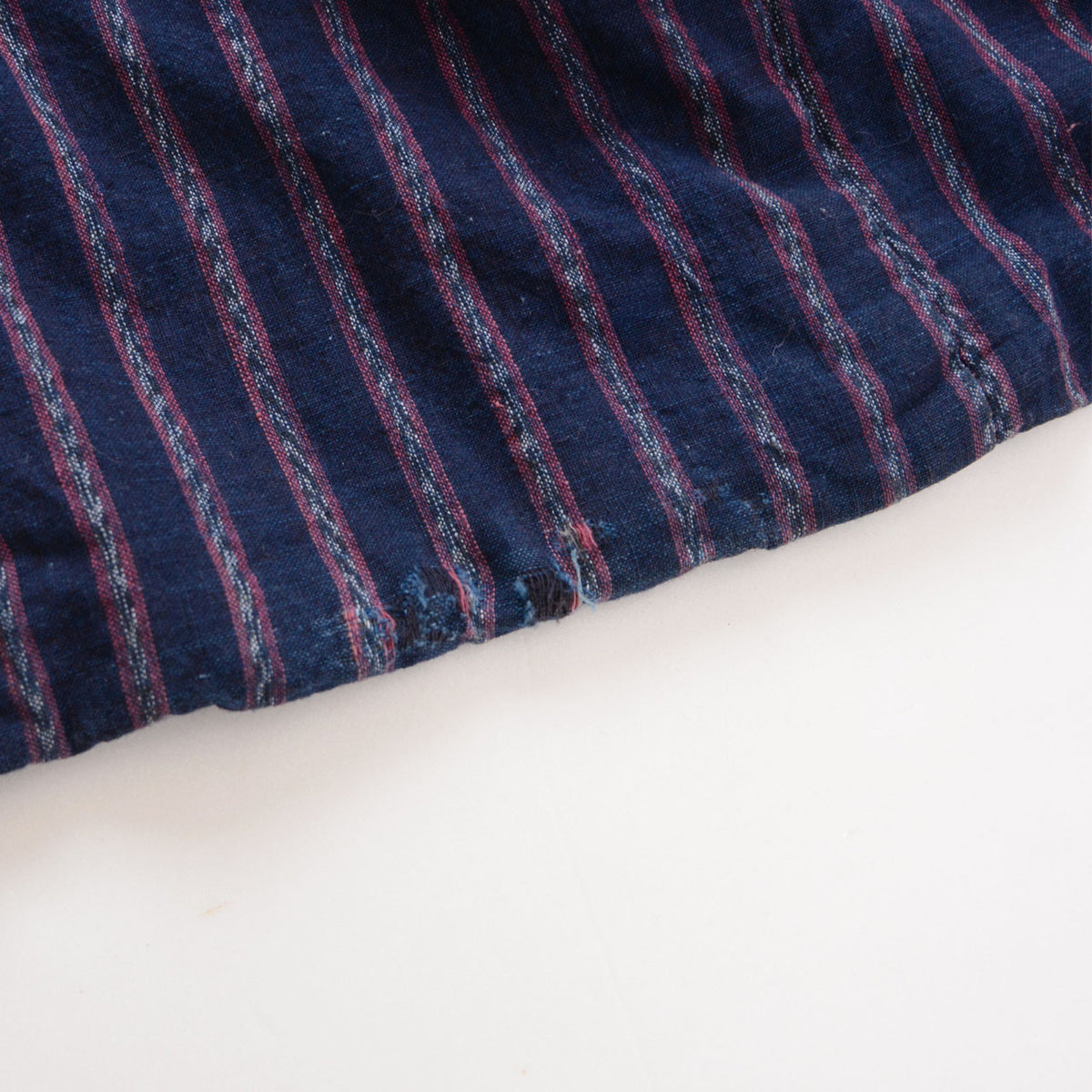 Close-up of the hem of an indigo-dyed striped cotton Japanese vintage noragi jacket