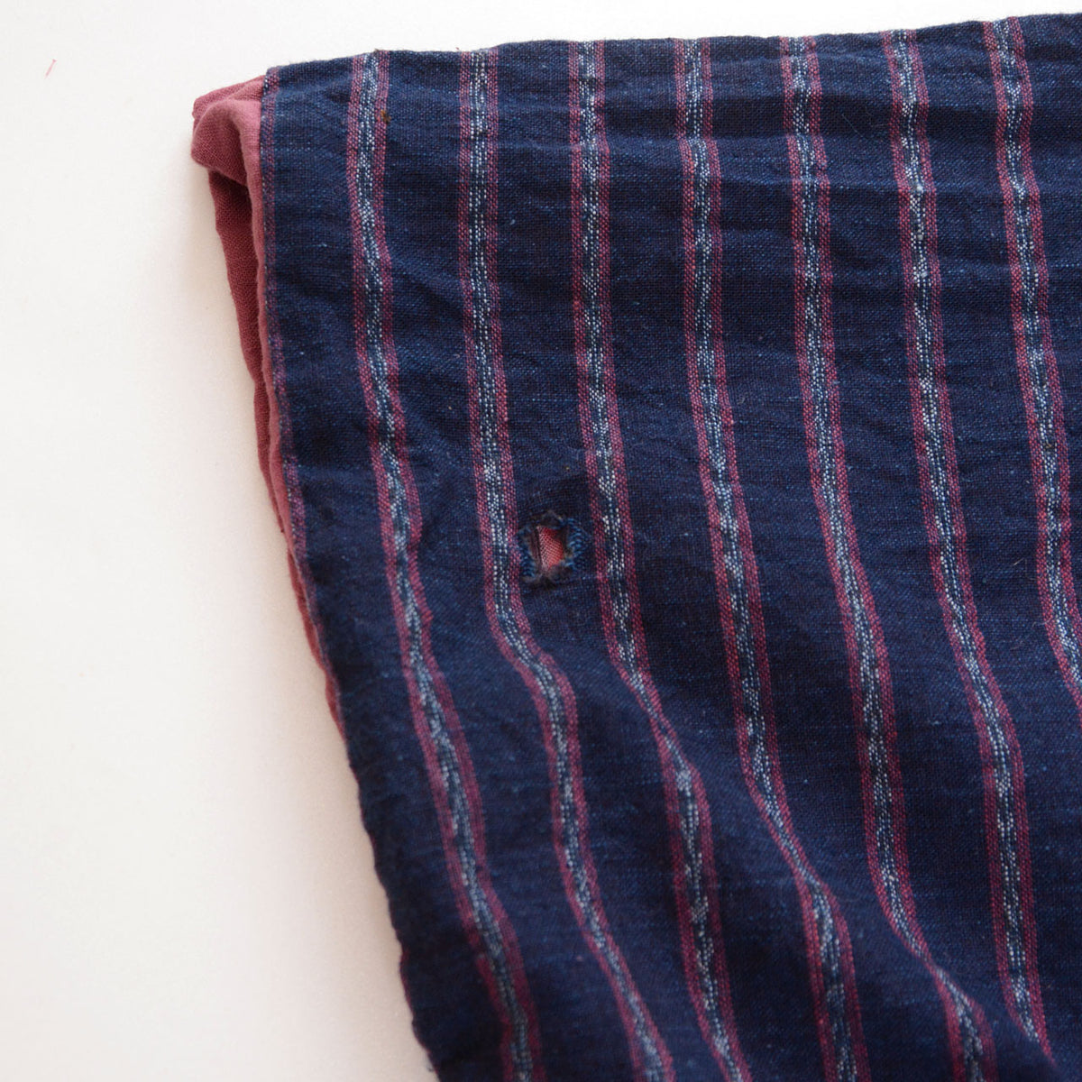 Close-up of a damaged sleeve in indigo striped cotton on a Japanese vintage noragi jacket