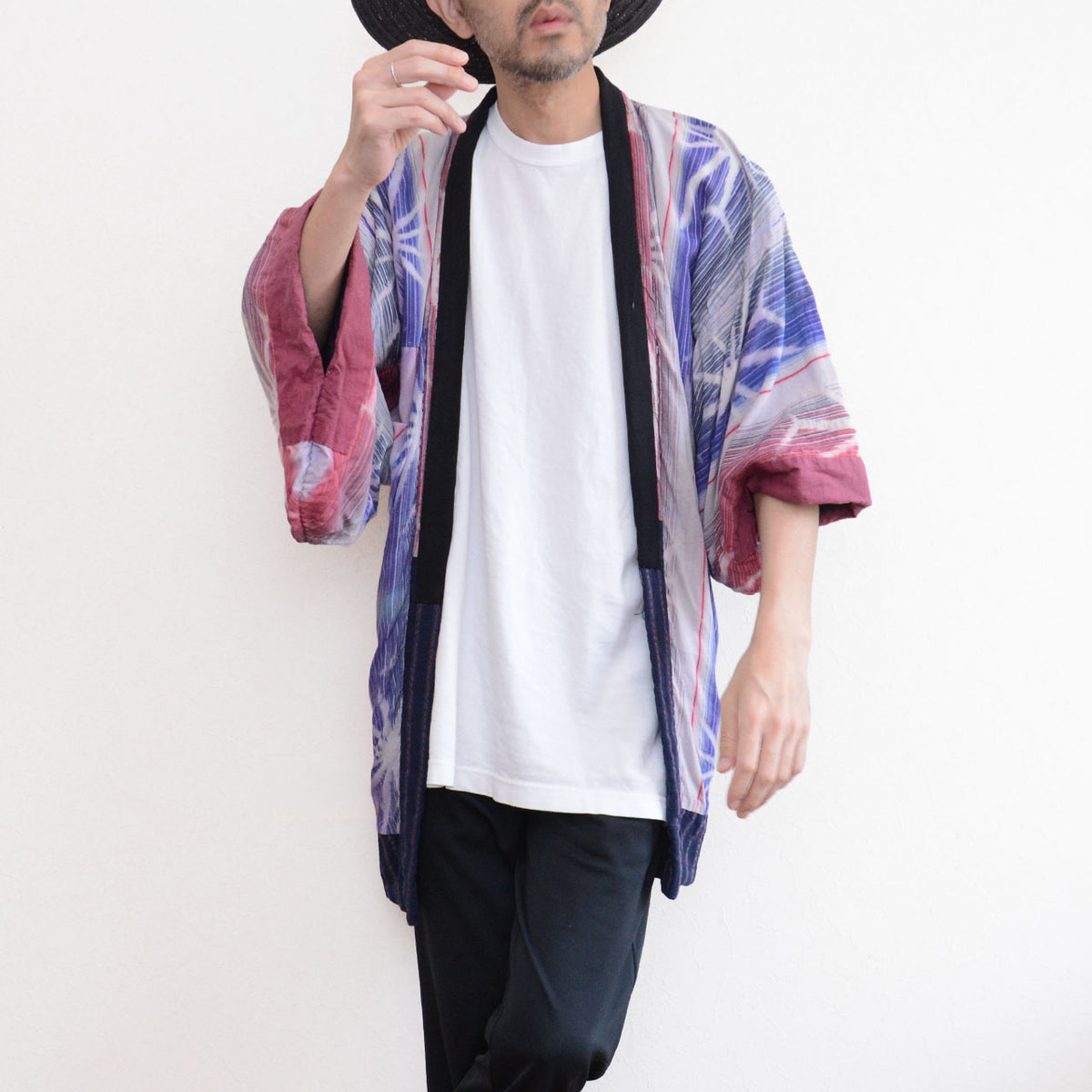 Front three-quarter view of a model wearing a Japanese vintage noragi jacket with colorful patterned cotton panels