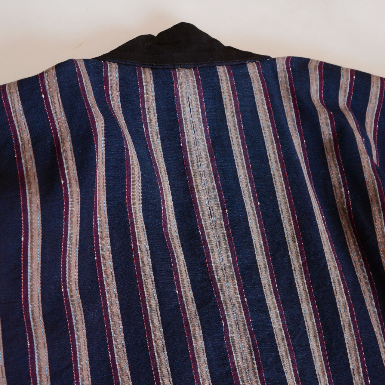 Aged cotton fabric with soft stripes, showcasing authentic vintage texture.