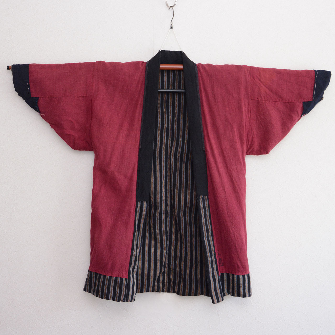 Vintage noragi jacket, inner side (crimson red cotton), on kimono hanger, front view — mid Showa era, Tohoku, Japan vintage