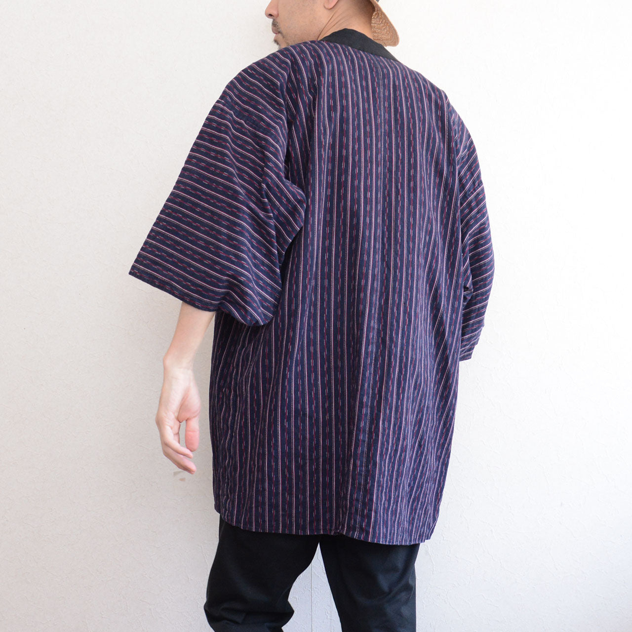 Navy cotton stripe noragi jacket worn, back view, styled over white tee and black trousers