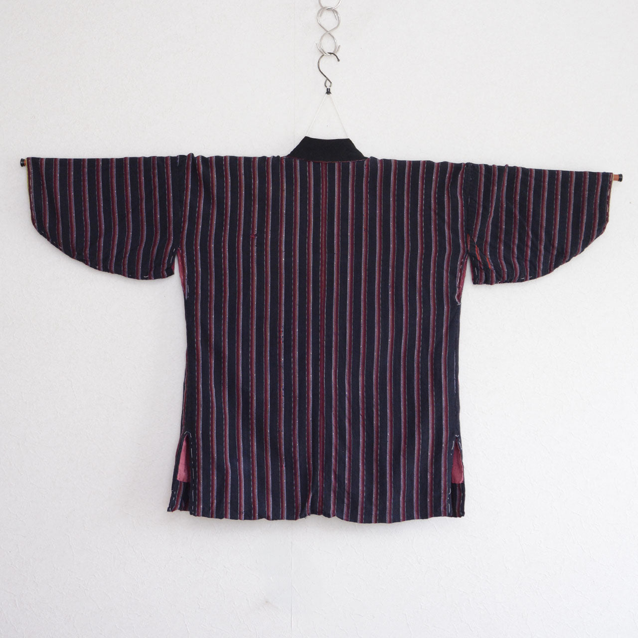 Japanese vintage noragi with red and gray vertical stripes and a salmon-pink lining visible at the side hems