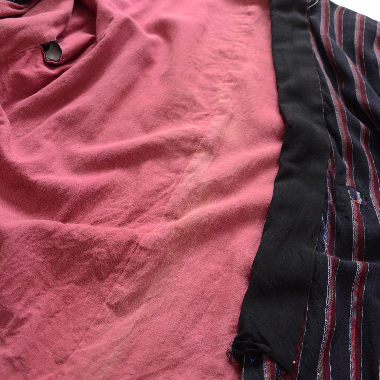 Japanese vintage noragi showing the salmon-pink lining, black front edging, and striped outer fabric