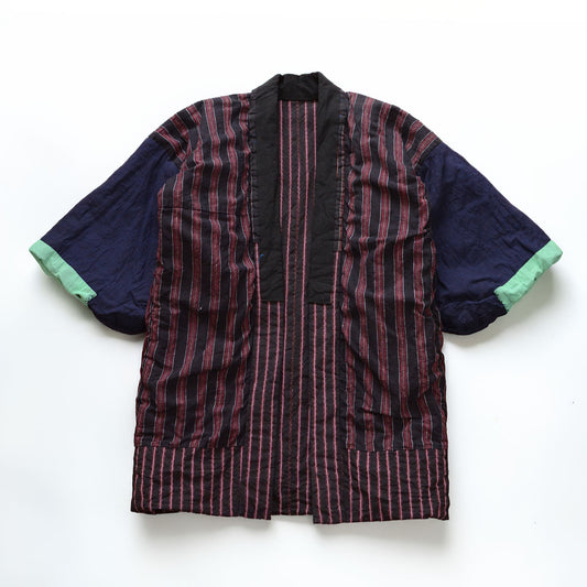 Japanese vintage cotton noragi showing the reverse side laid flat, with a striped body, solid navy sleeves, mint-green cuffs, and a crazy-pattern lining