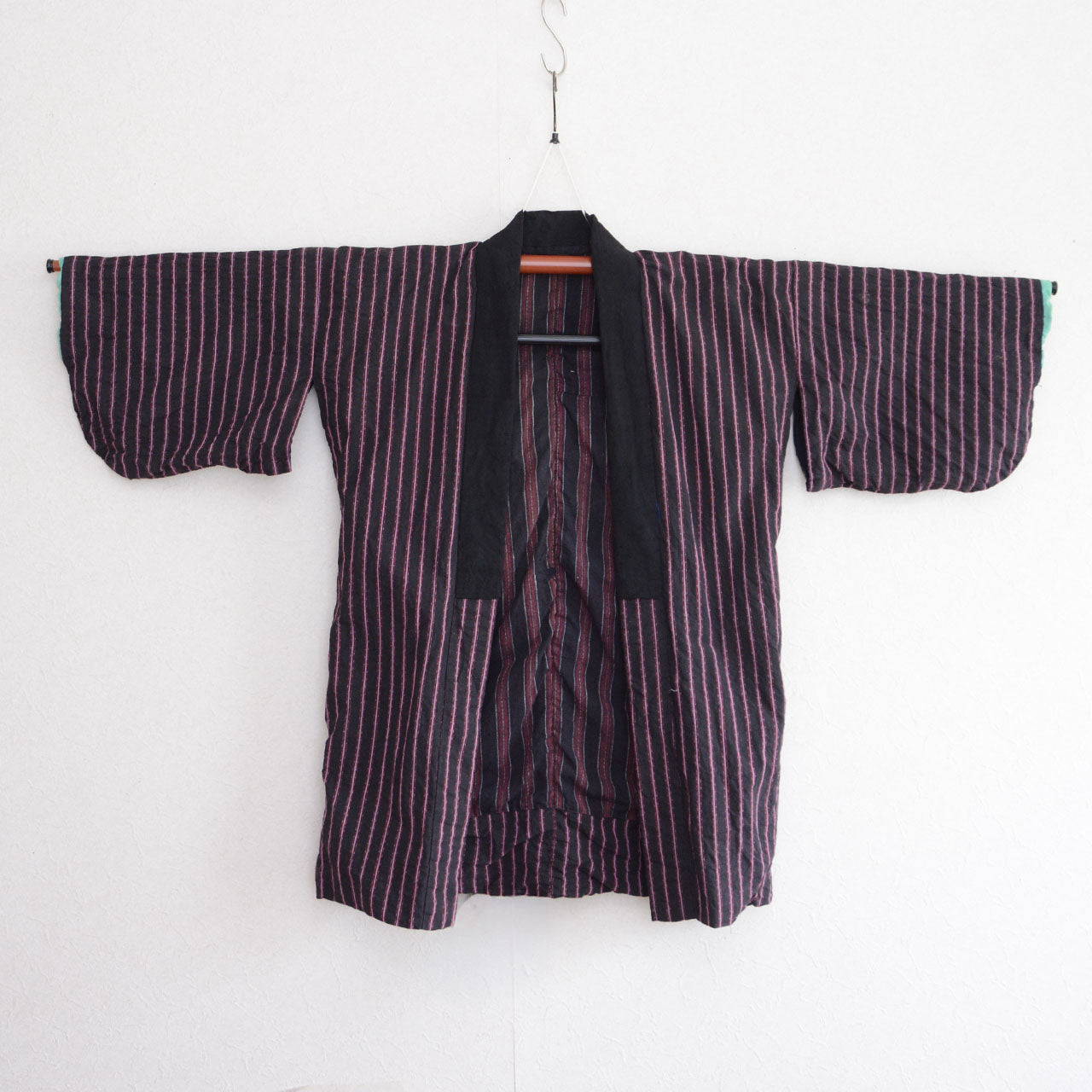 Japanese vintage cotton noragi on a kimono hanger, showing dark vertical stripes and a relaxed everyday silhouette