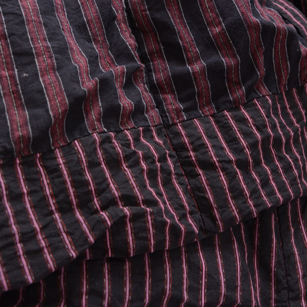Reverse side of a Japanese vintage noragi showing contrasting striped cotton fabrics used in the body and hem