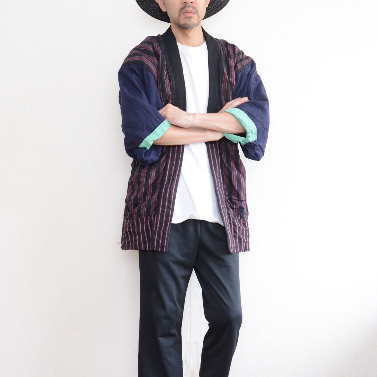 Model wearing a Japanese vintage noragi with a striped back, navy sleeves, mint-green cuffs, and track pants
