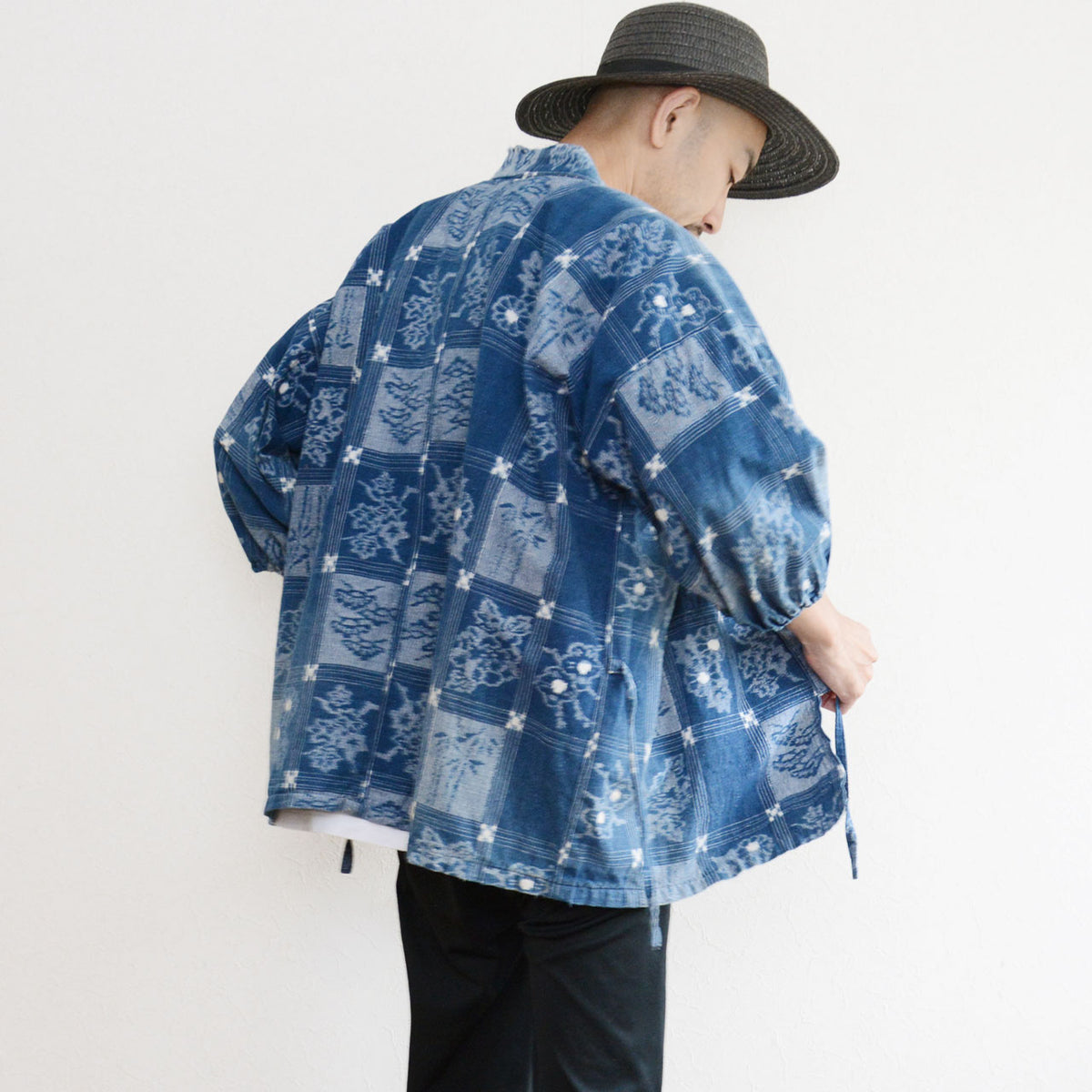 Vintage indigo cotton uwappari noragi jacket worn by a model, with botanical grid motifs and gathered cuffs