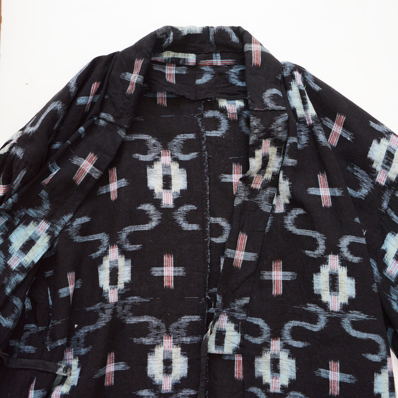 Front opening of dark navy kasuri cotton noragi uwappari jacket, cross ikat pattern visible across body, Showa era Japan vintage