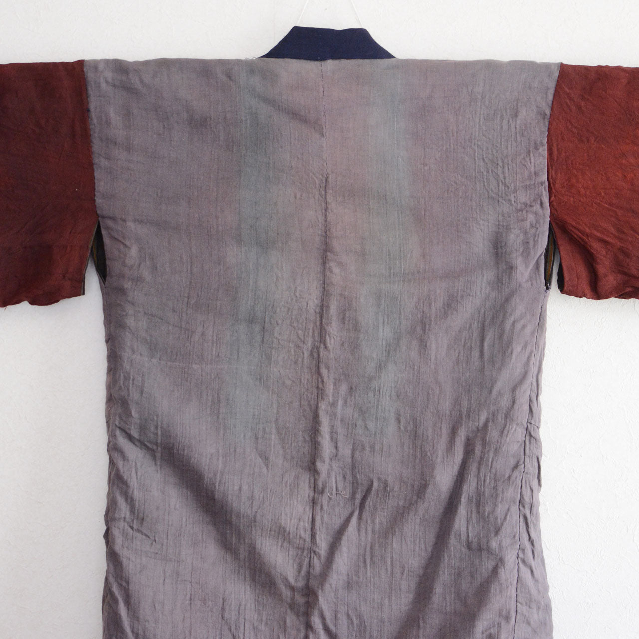 Vintage Japanese noragi jacket, Showa era, gray mixed fabric body with navy collar, multicolor stripe lining visible at front opening, fabric layers detail