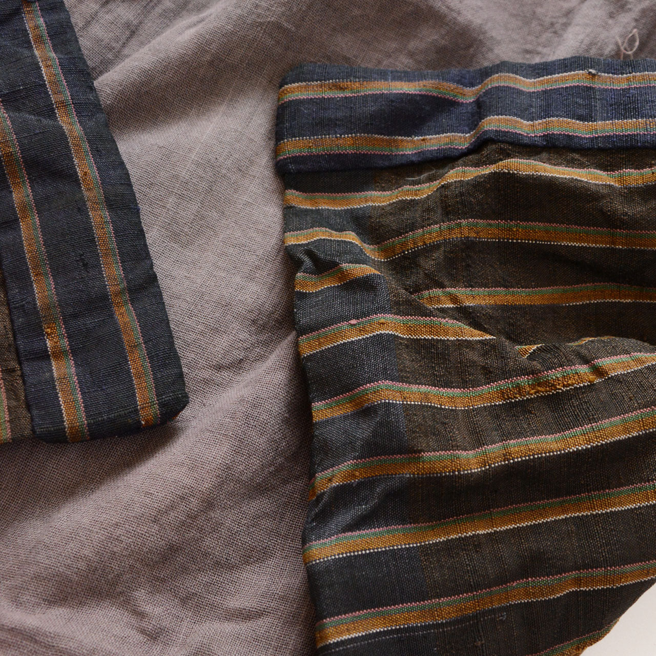 Vintage Japanese noragi jacket, Showa era, gray mixed fabric body with navy collar and multicolor stripe lining, three fabric layers visible at front opening, interior construction detail
