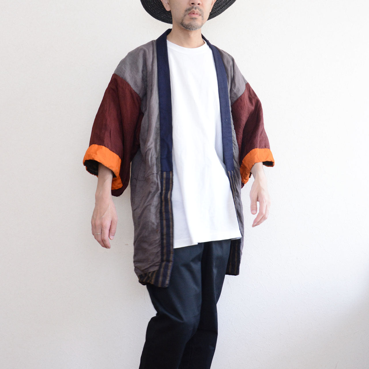 Vintage Japanese noragi jacket, Showa era, gray mixed fabric body with burgundy and orange patchwork sleeves, worn open over white t-shirt and dark trousers, front view, model height 171cm