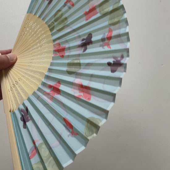 Japanese folding fan gently fanned open showcasing goldfish and demekin design