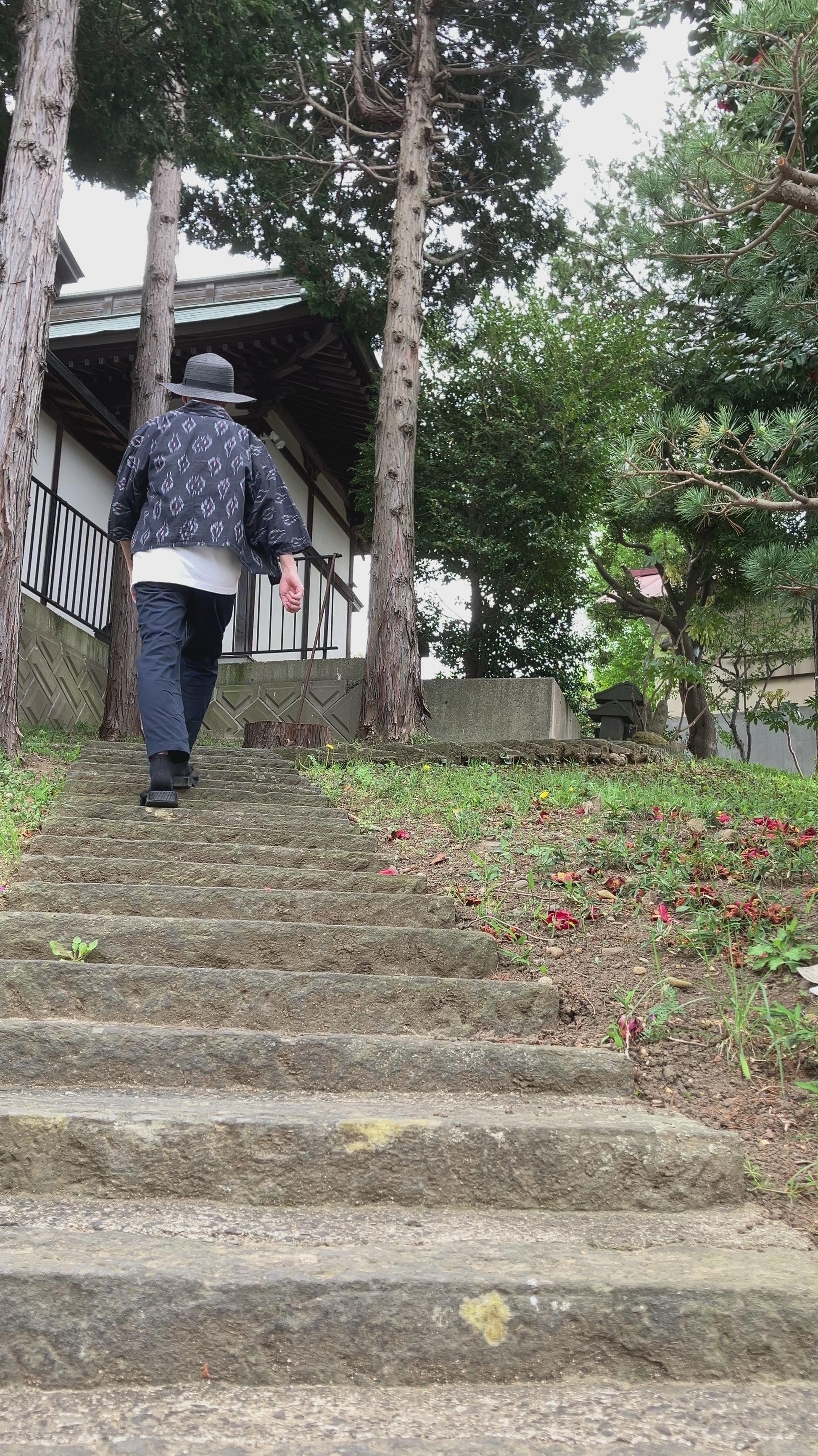 Faded black kasuri noragi worn while climbing stone steps of a Japanese shrine, mid-Showa era Japan vintage slow fashion