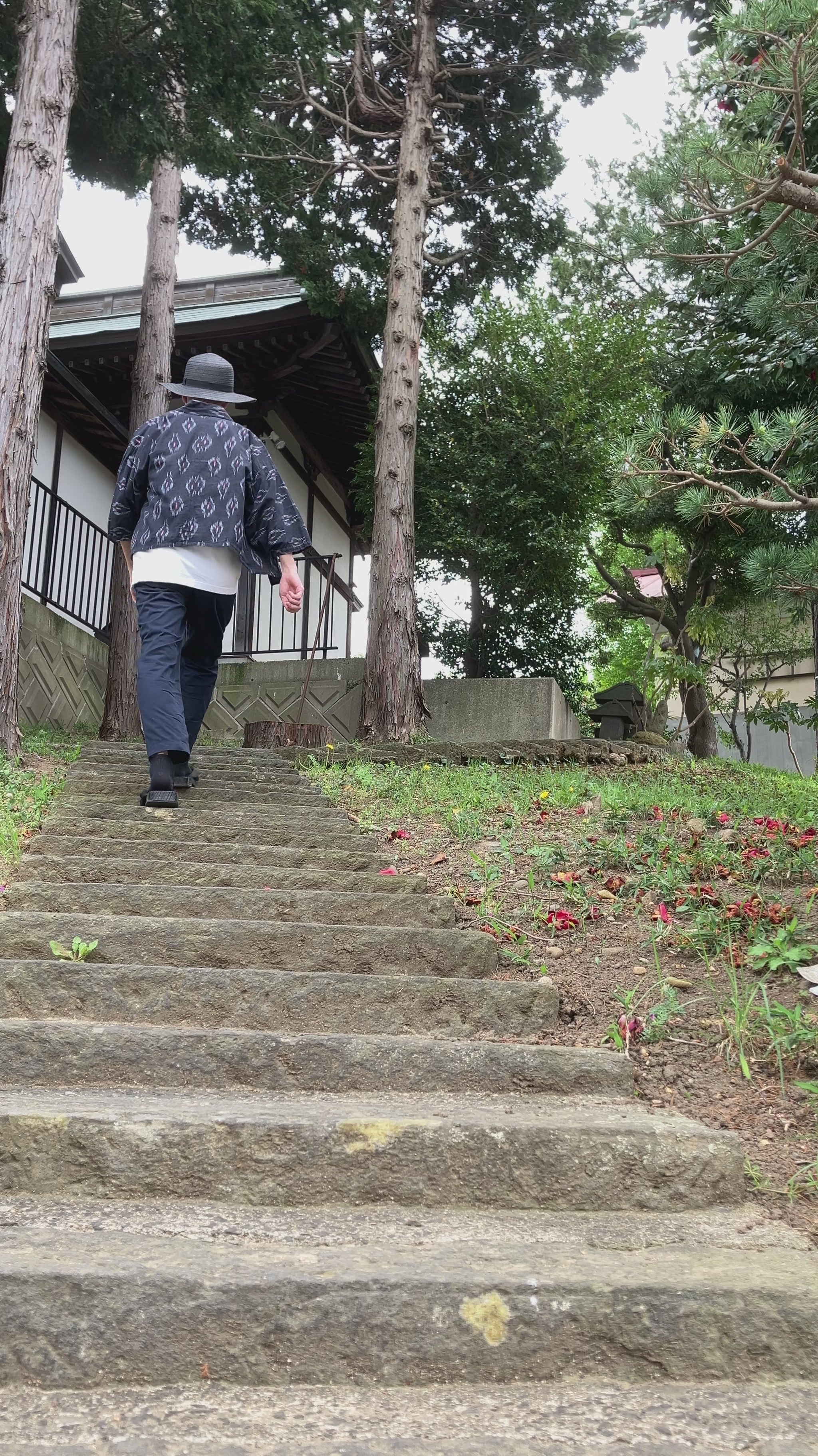 Faded black kasuri noragi worn while climbing stone steps of a Japanese shrine, mid-Showa era Japan vintage slow fashion